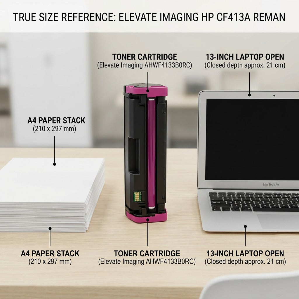 A high-resolution product photograph shows the magenta laser toner cartridge (Elevate Imaging AHWF4133B0RC-CF413A) positioned upright on a natural wood desk, in front of a standard 13-inch open laptop. A stack of A4 copier paper is next to the cartridge. Clear definition of size scale is achieved.