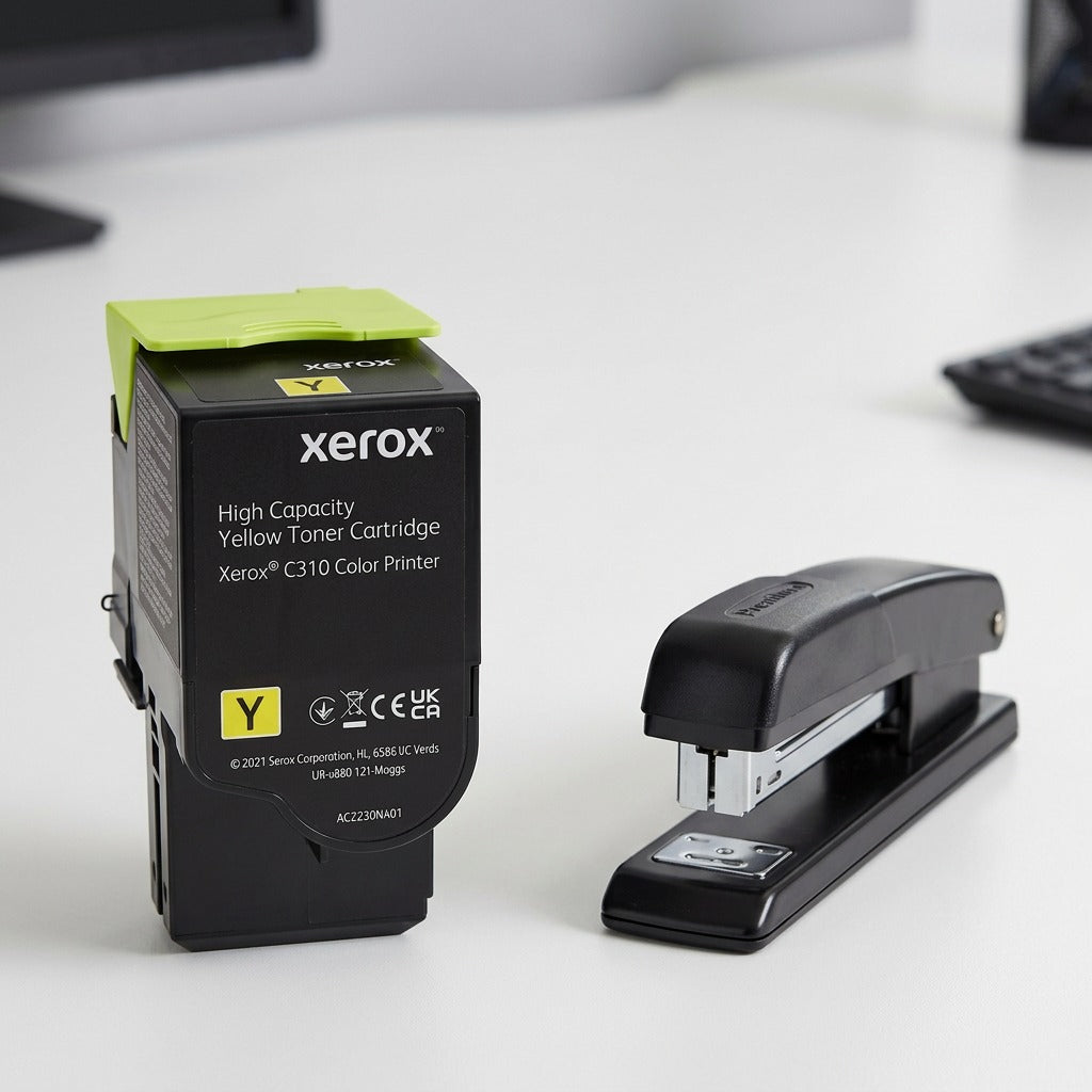 Scale reference photo for Xerox C310 yellow toner, shown next to a common office stapler.