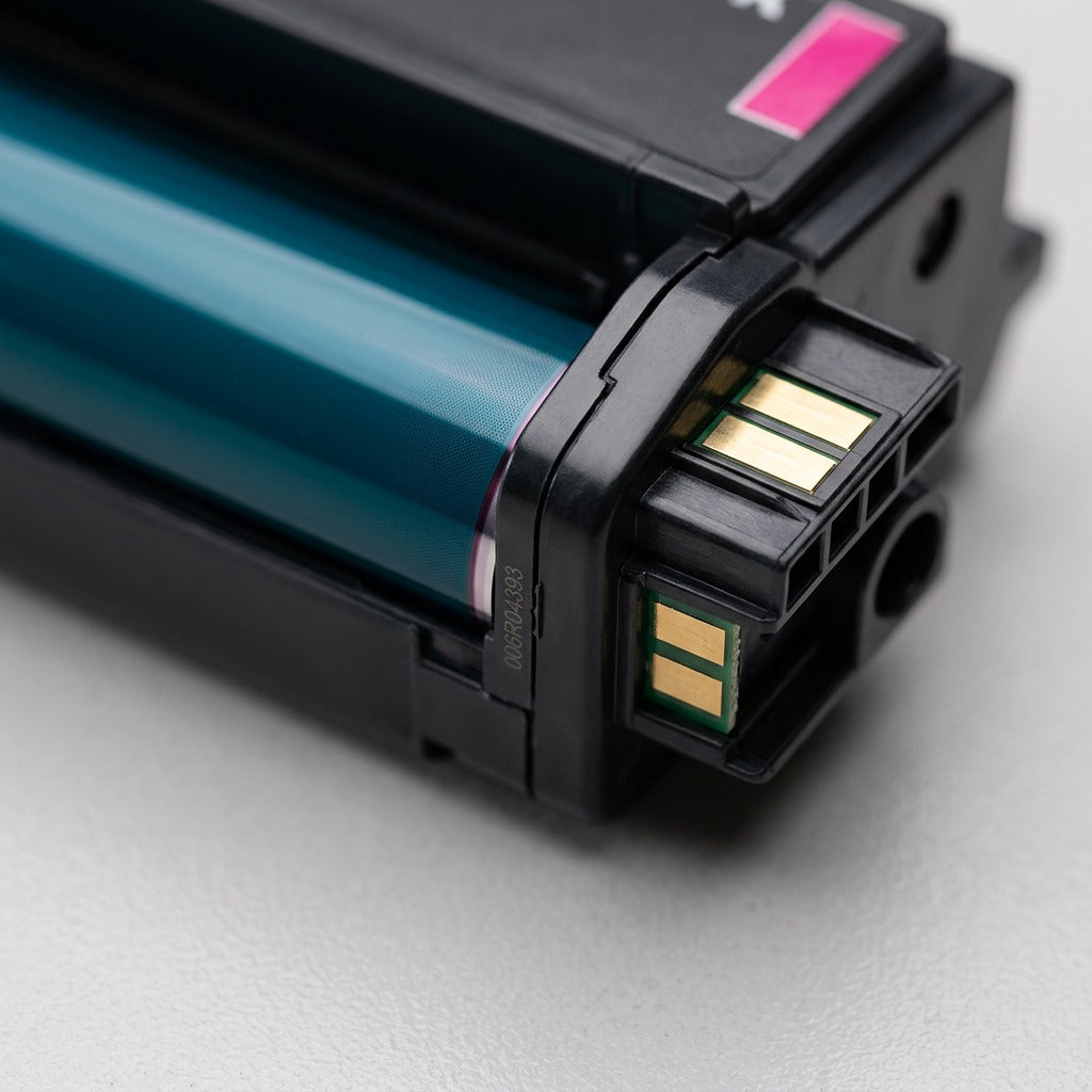 Extreme macro view showing the precise alignment of the magenta print drum and electrical contact point on the Xerox cartridge.