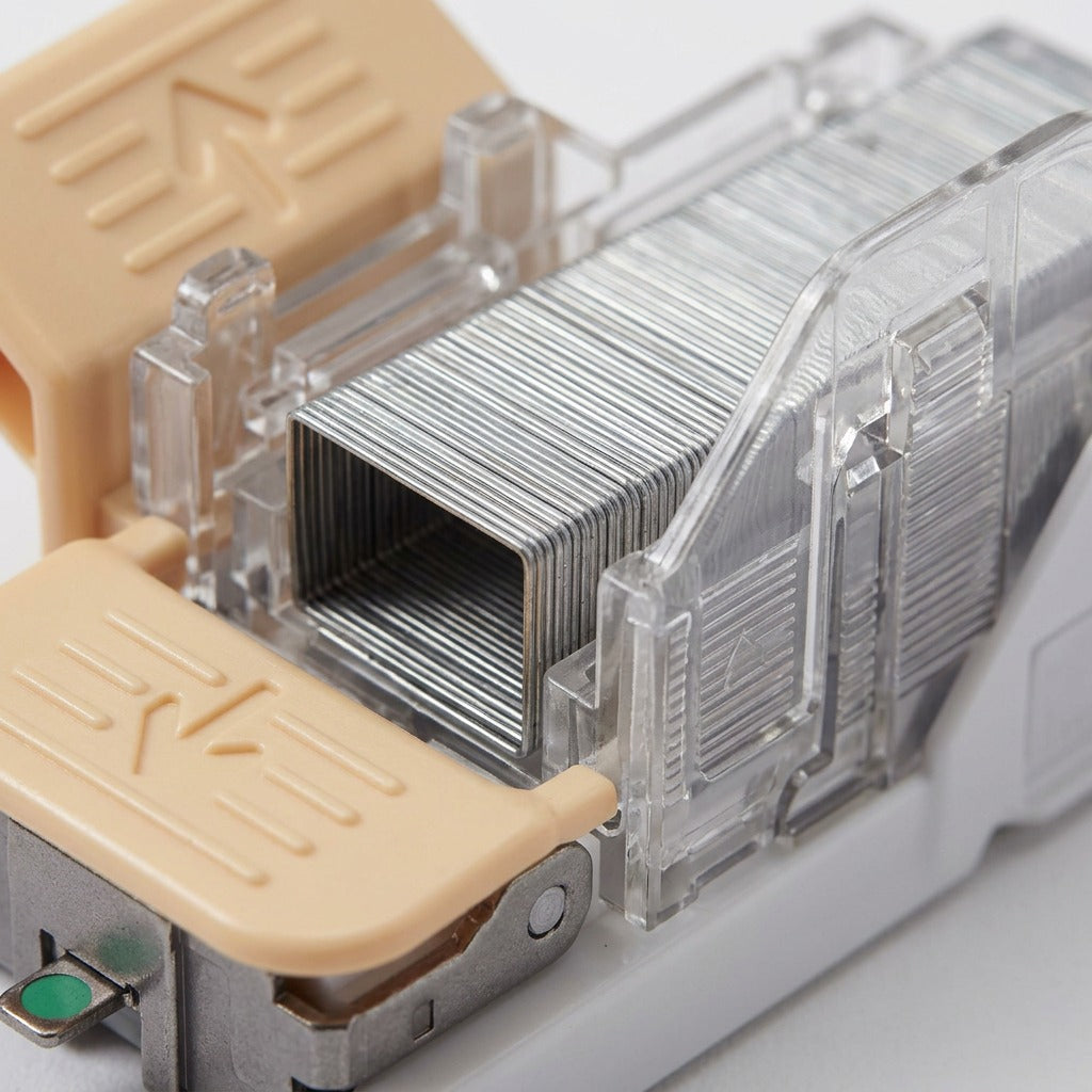 A high-resolution macro photograph concentrating on the metallic staples, visible through the transparent cartridge housing of the Xerox 008R12964 main staple cartridge, with a shallow depth of field.