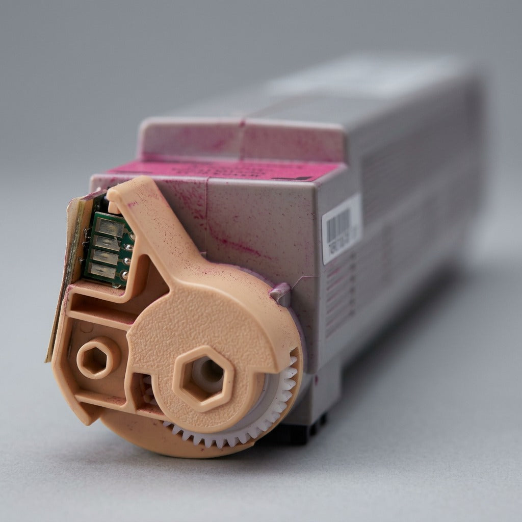 Extreme close-up macro detail of the pink magenta-coded connector end and gear on the Xerox 106R01078 toner cartridge.