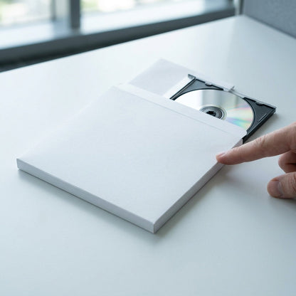 A visual scale reference image showing the Xerox software kit (a white box and disc) on a desk, next to a human hand.