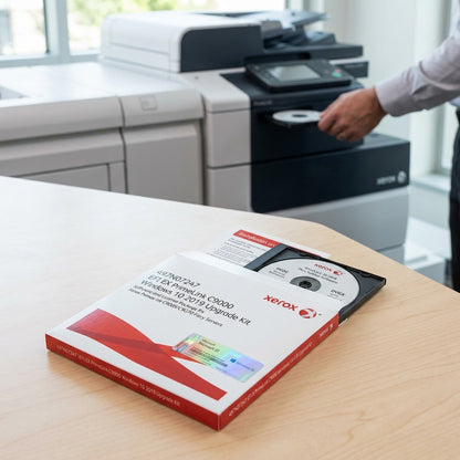 A photo of the Xerox EFI EX PrimeLink C9000 Windows 10 Upgrade Kit (SKU 497N07247) displayed on a clean wooden desk next to a modern printer.