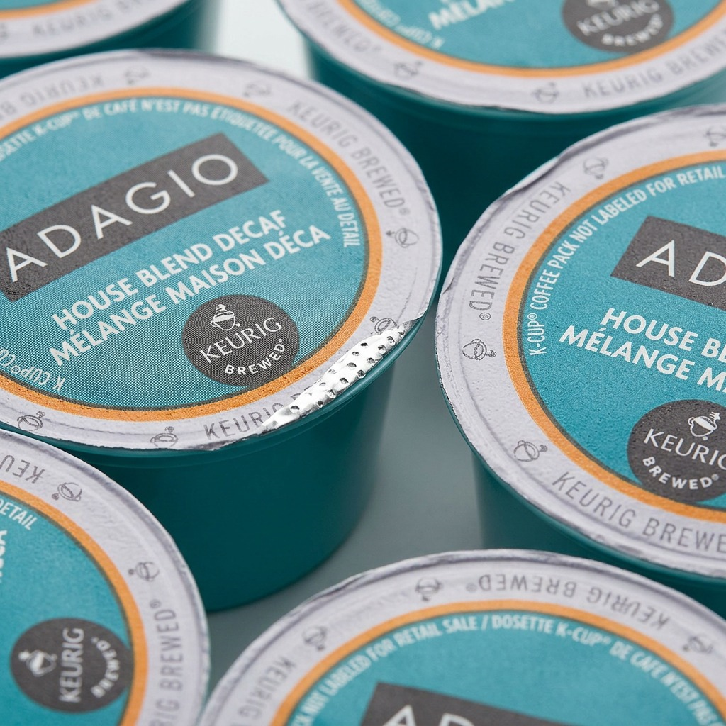 Detail macro photograph of Adagio K-Cup foil lid showing textured print and tiny air perforations.