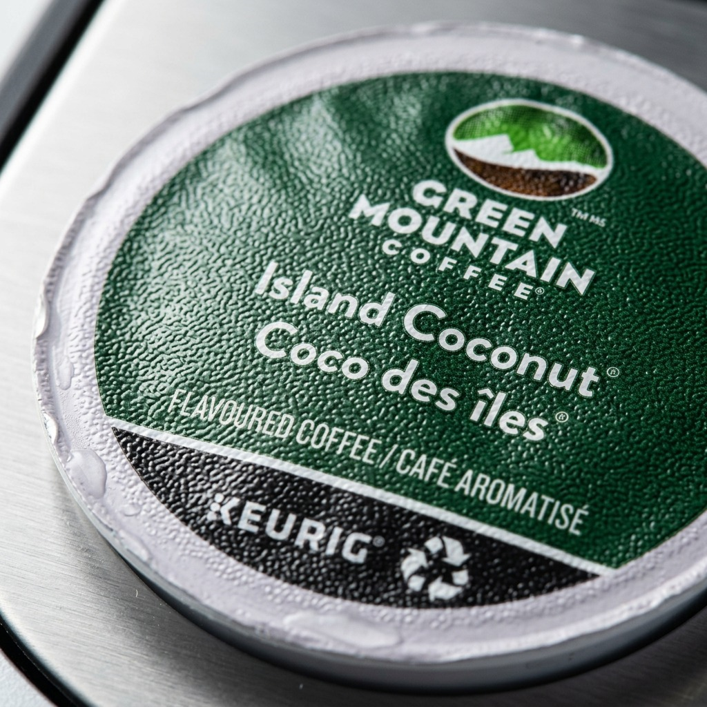 Macro view focusing on the clear print on the textured foil lid of an Island Coconut K-Cup.