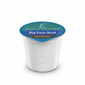 A high-resolution, centered view of an individual Emeril Lagasse Big Easy Bold dark roast K-Cup pod against a pure white background, showcasing its shape, foil lid branding, and textured sides.