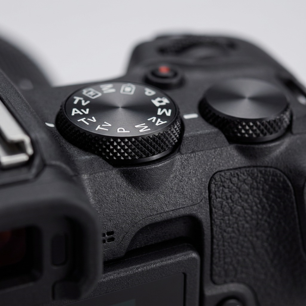 Macro close-up shot focusing on the textured control dial of the Canon EOS R50 camera.