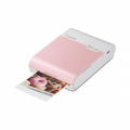 Pure hero shot of the Canon SELPHY Square QX10 pink printer, showing it ejecting a donut photo, centered on plain white.