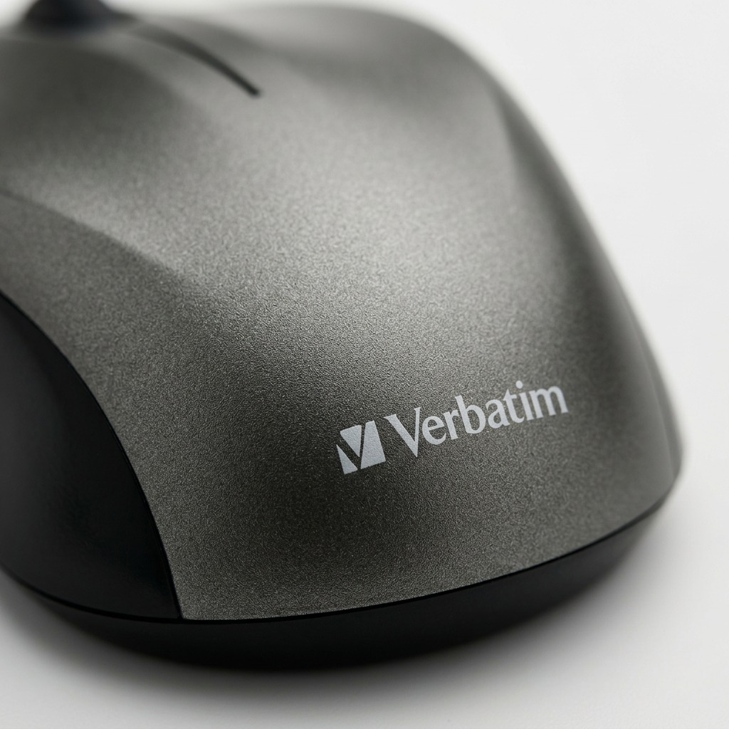 An extreme macro photograph of the Verbatim logo and graphite texture on the back of the mouse.