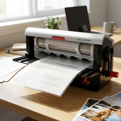 A Xyron 9" ezLaminator in a lifestyle context, placed on a wooden desk with office supplies.