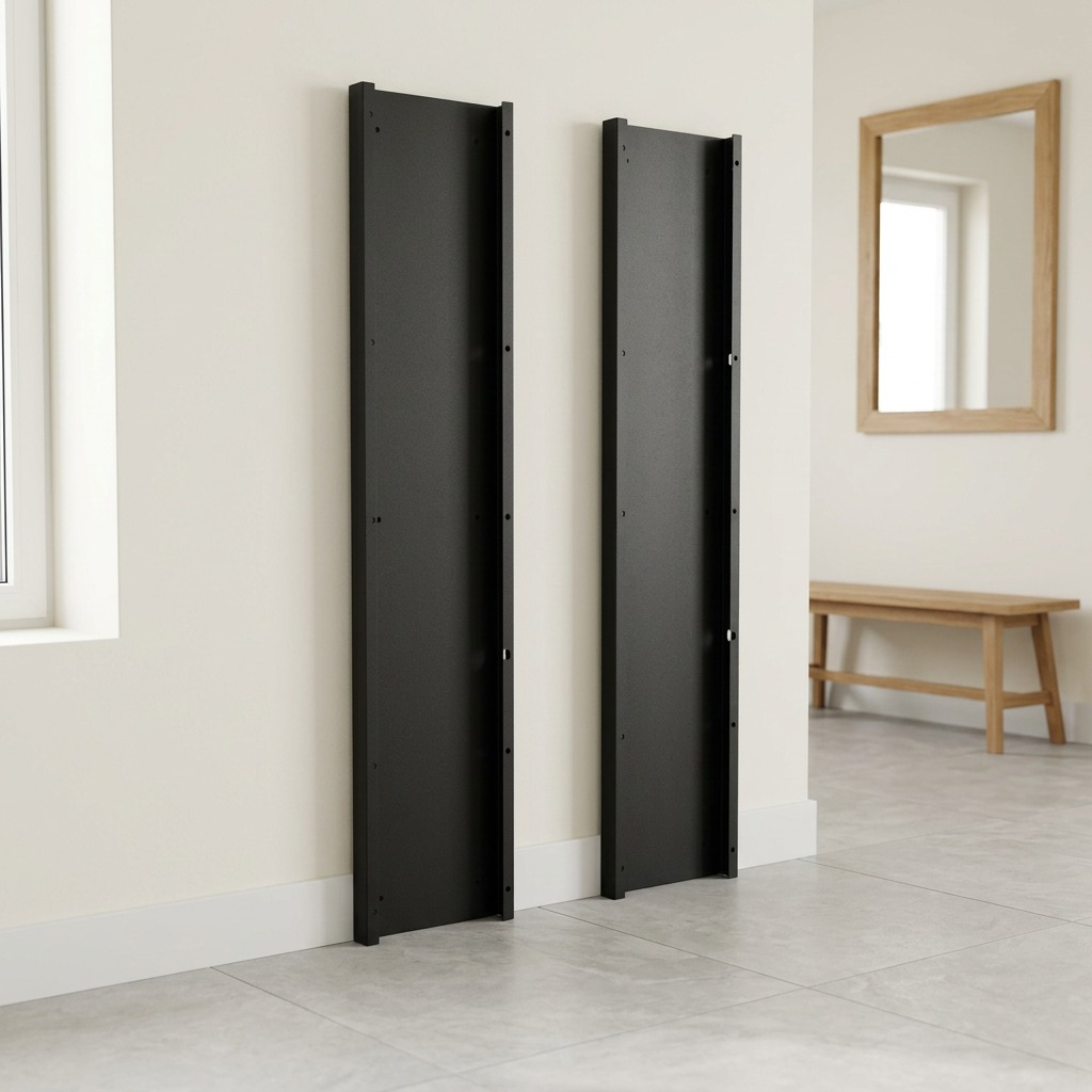 Two matte black Rakabot metal side panels, as seen in image_0.png, stand vertically against a home entryway wall. Grounded on grey tiles, they are positioned near a window, with a wooden bench and mirror visible in the background, showing a realistic lifestyle context.