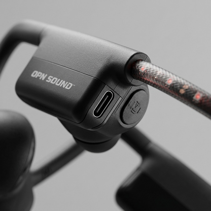 Macro view of OPN Sound Dashlyte+, highlighting USB-C port, power button, and text print. OPN Sound Dashlyte+ open-ear directional audio headphones angled view