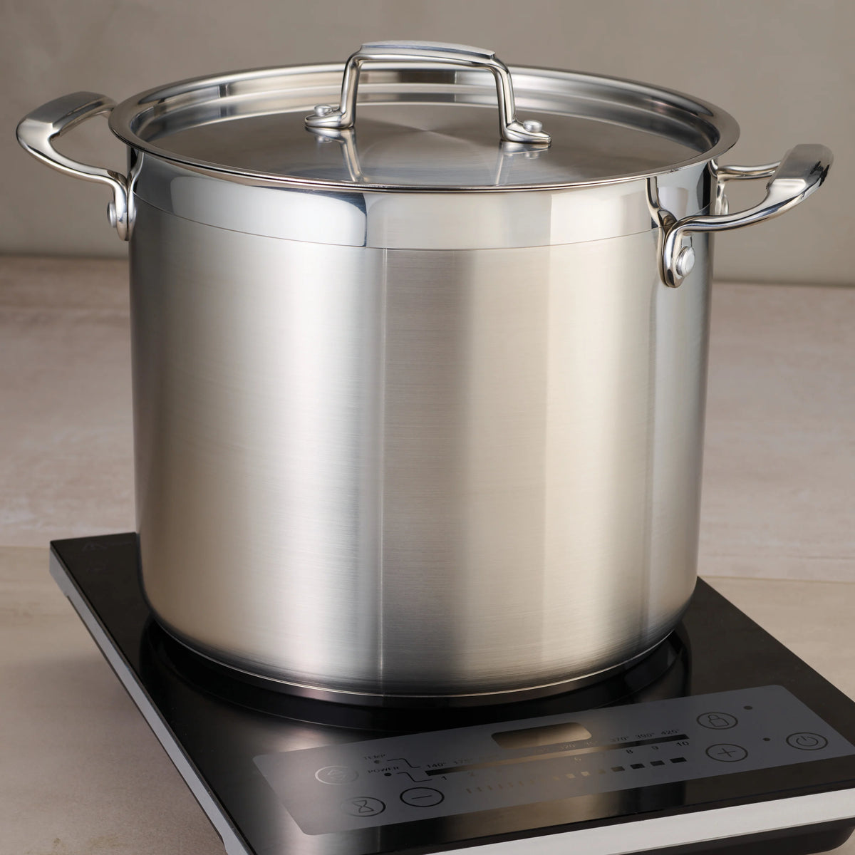 Tramontina 24 Qt tri-ply stainless steel stock pot on induction cooktop